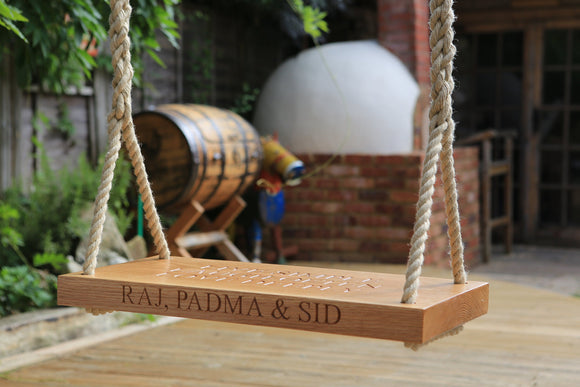 Oak garden swing with carved text on the front and top